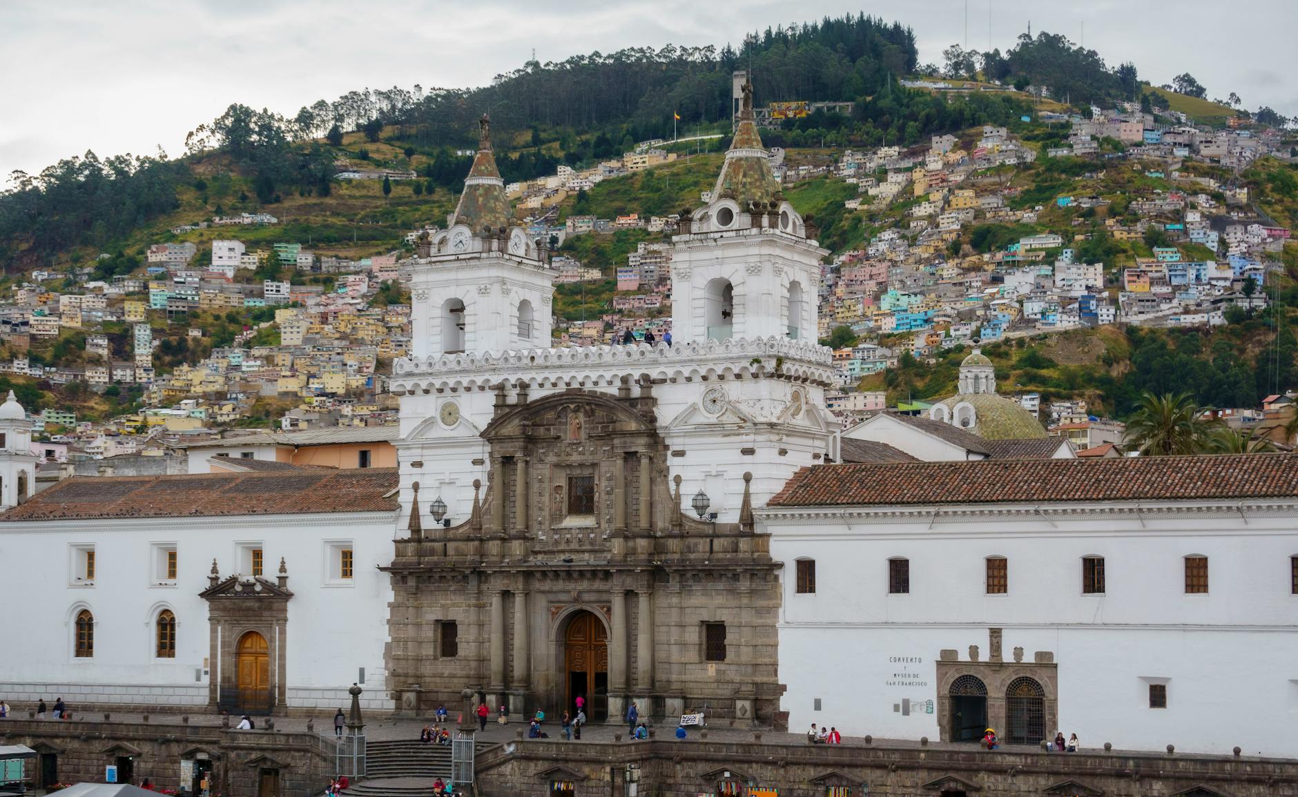 Vista del centro histórico de Quito con iglesias barrocas y calles empedradas al atardecer