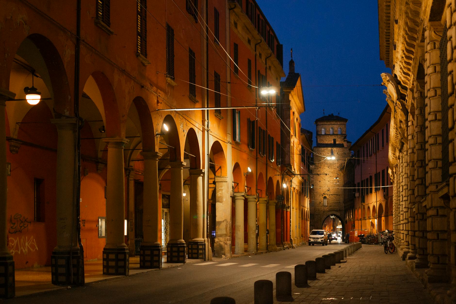 Pórticos medievales del centro histórico de Bolonia con luz cálida al atardecer