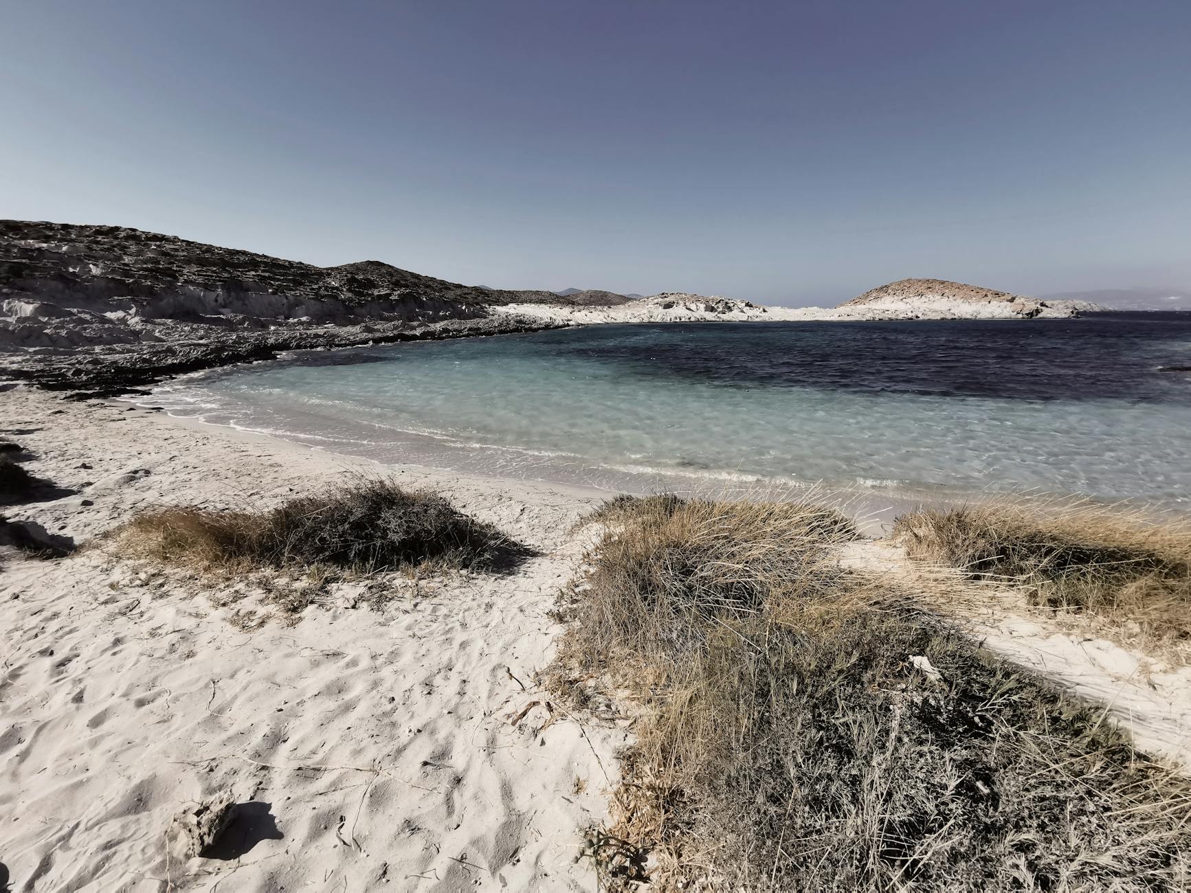 Vista aérea de una isla mediterránea poco masificada con aguas turquesas