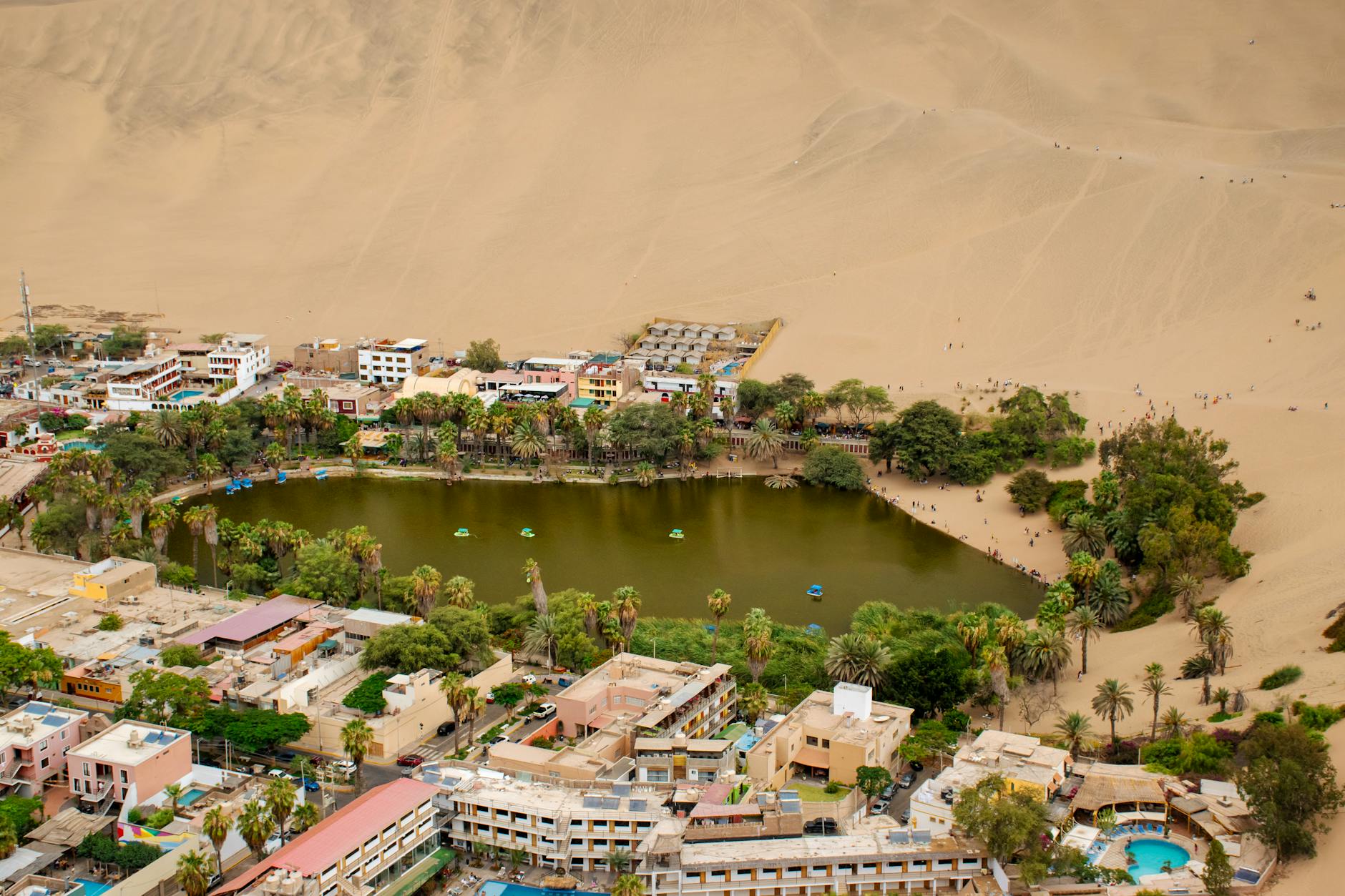 Atardecer con colores cálidos reflejados en la laguna del oasis de Huacachina