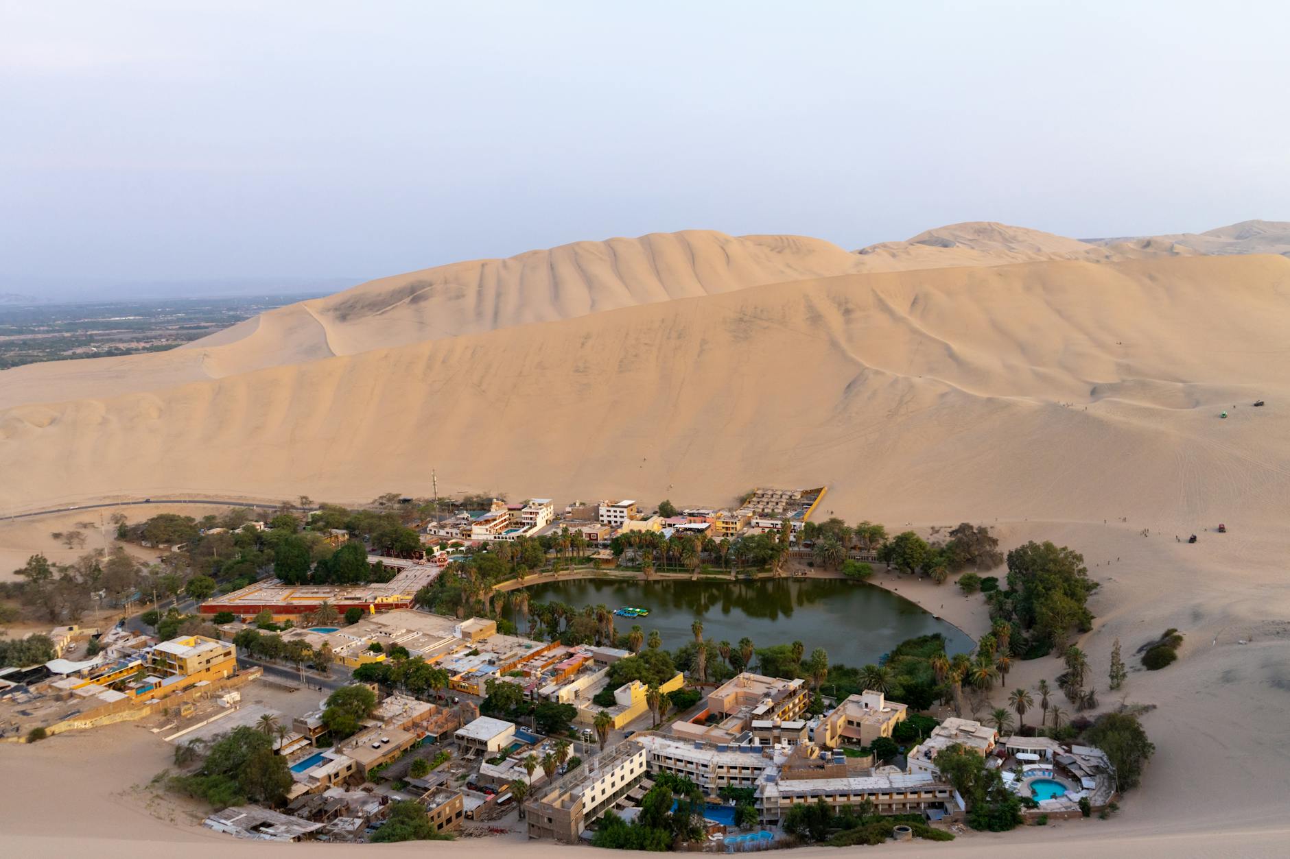 Vista panorámica del oasis de Huacachina rodeado de dunas en el desierto de Ica, Perú