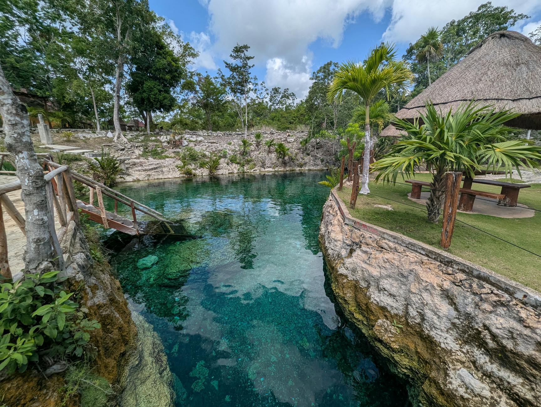 Interior de un cenote en Tulum con aguas cristalinas turquesa y rayos de luz solar