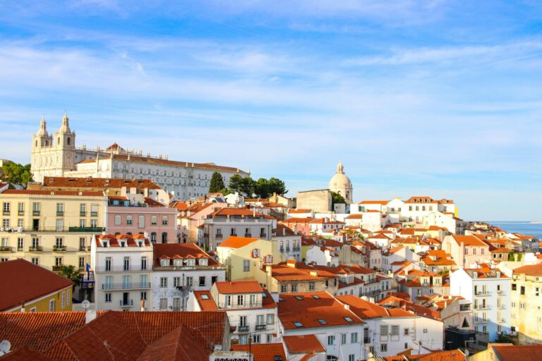 Vistas panorámicas desde el mirador de Alfama en Lisboa con tejados naranjas y el río Tajo al fondo