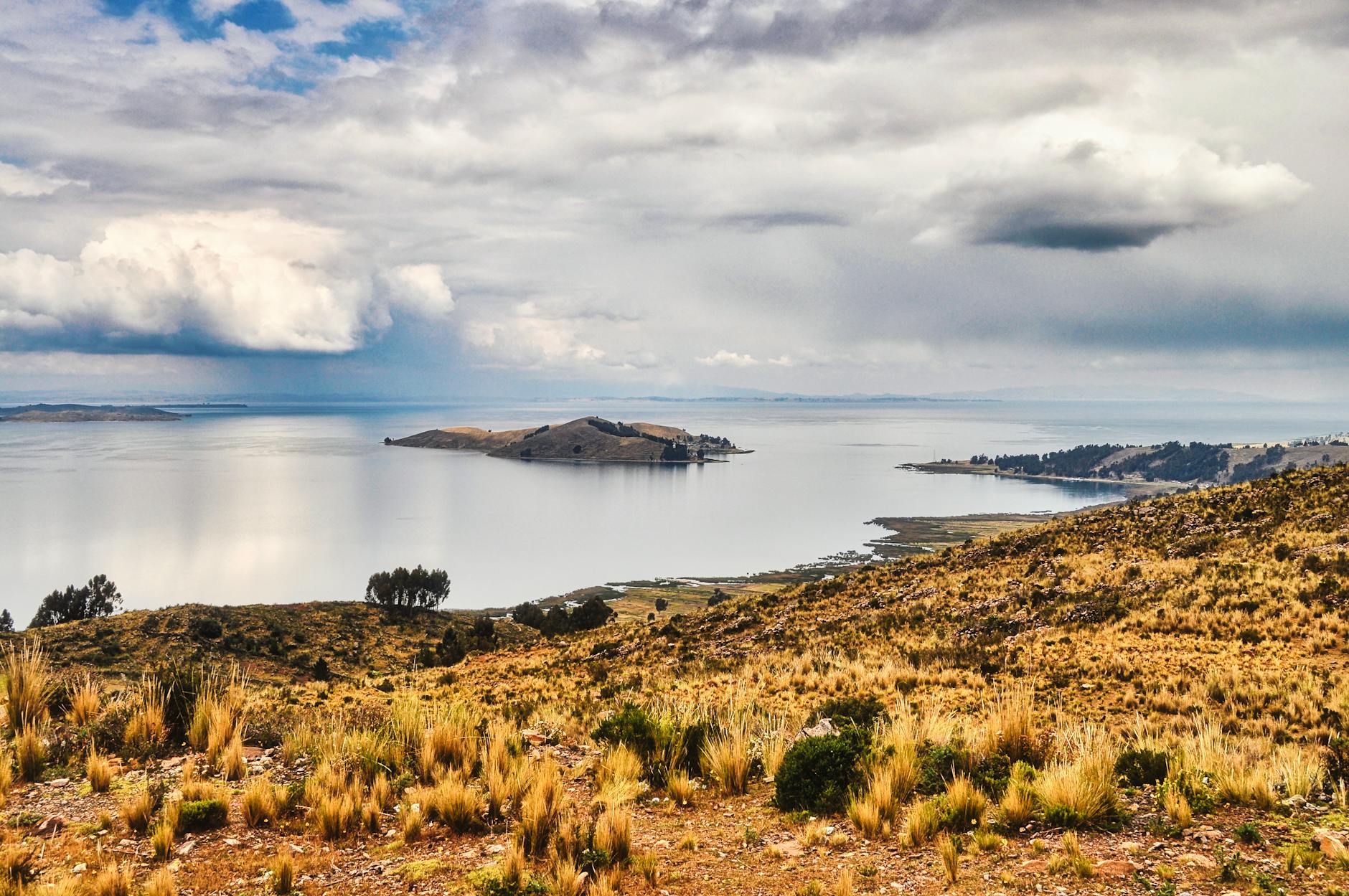 Mujer aimara con vestimenta tradicional colorida frente al Lago Titicaca en Puno