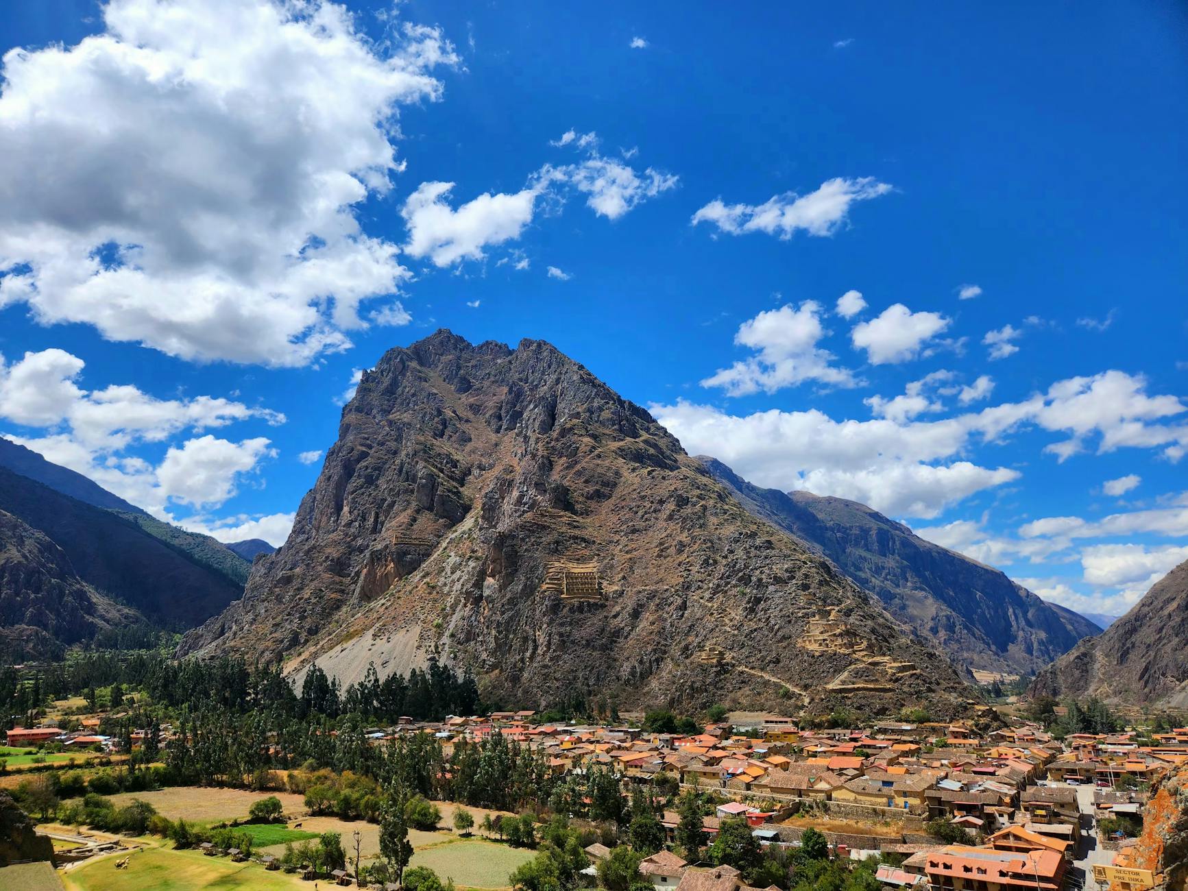 Puestos de artesanía andina con textiles coloridos en el mercado de Pisac, Perú