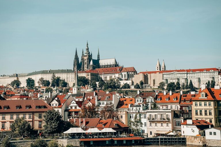 Vista del Puente de Carlos al atardecer con las torres góticas iluminadas en Praga