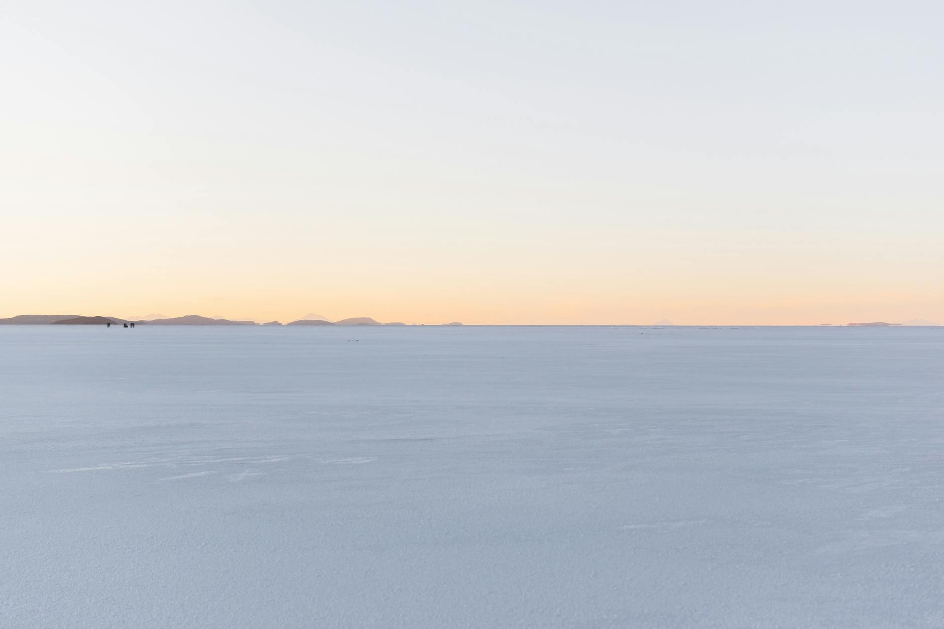 Vista panorámica del Salar de Uyuni con el reflejo perfecto del cielo al amanecer