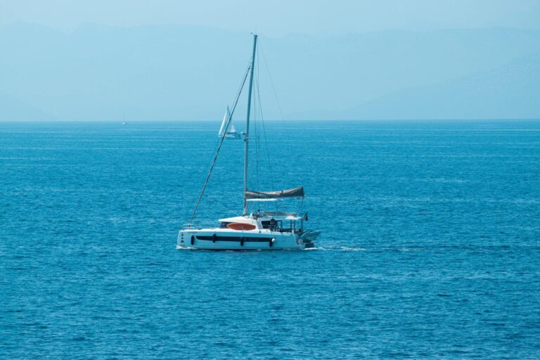 Velero surcando el mar turquesa de las Islas Jónicas con Corfú al fondo