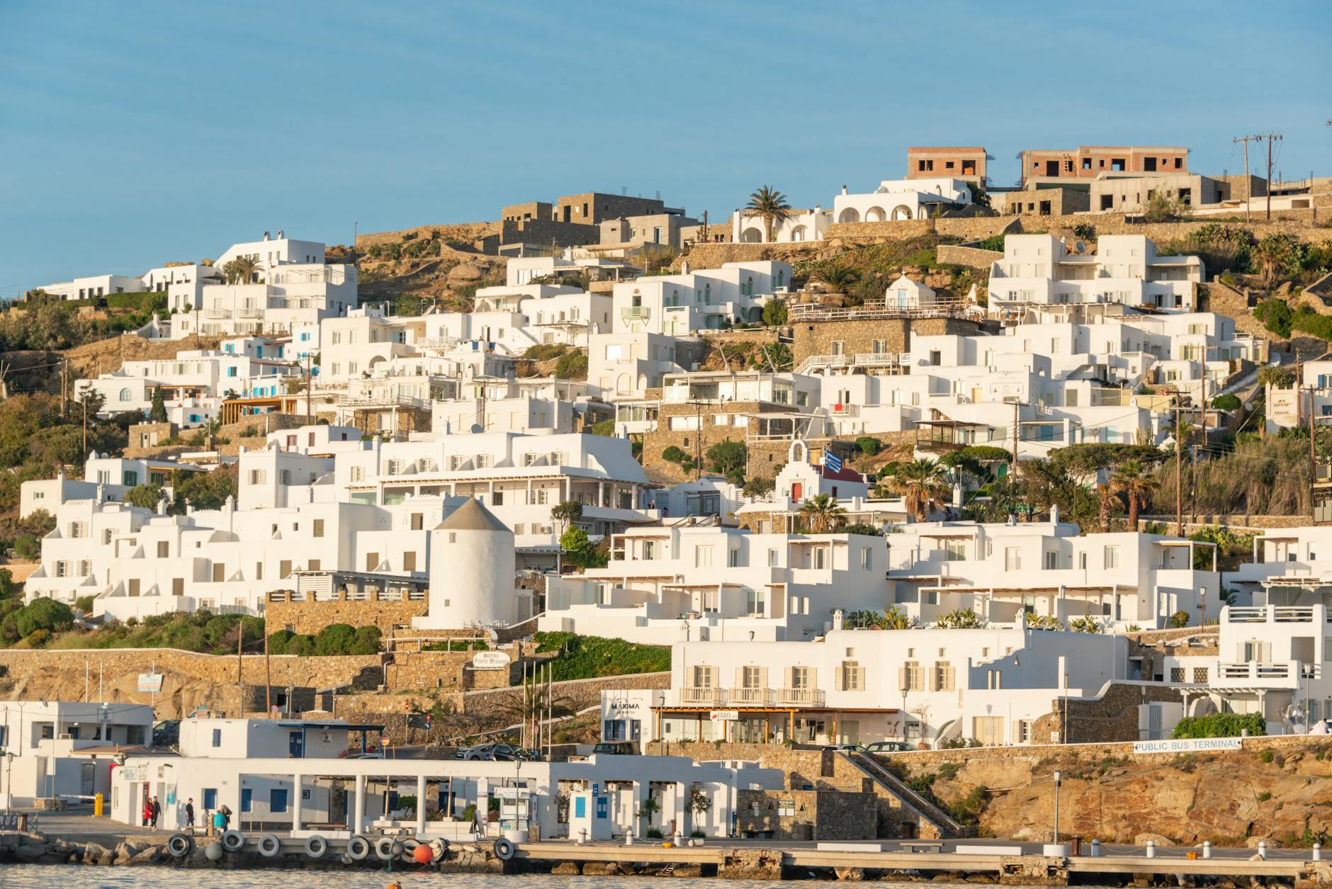 Atardecer naranja sobre Little Venice en Mykonos con casas de colores sobre el mar