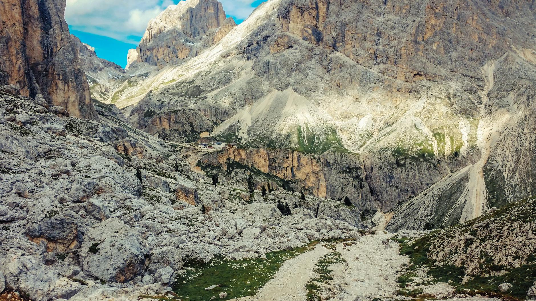 Senderista frente a las torres rocosas de las Dolomitas en un día despejado