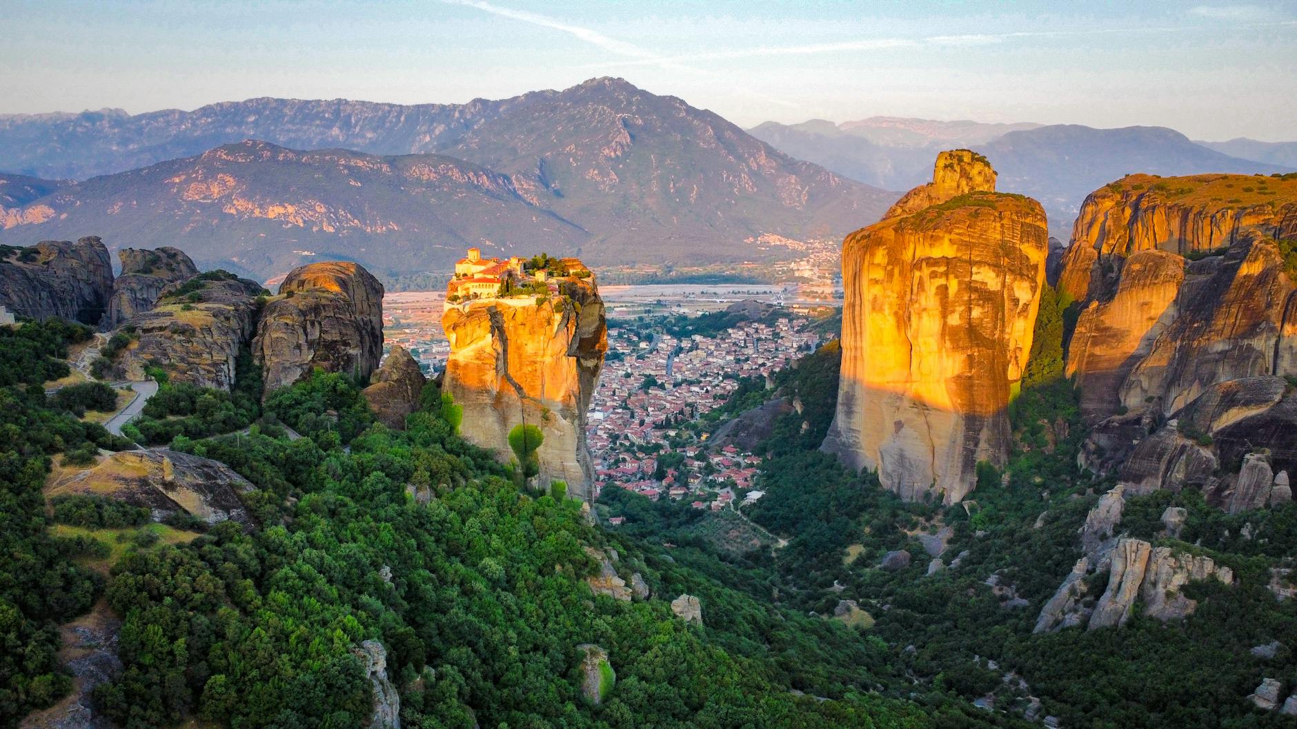 Vistas del amanecer sobre las rocas de Meteora con niebla y monasterios al fondo
