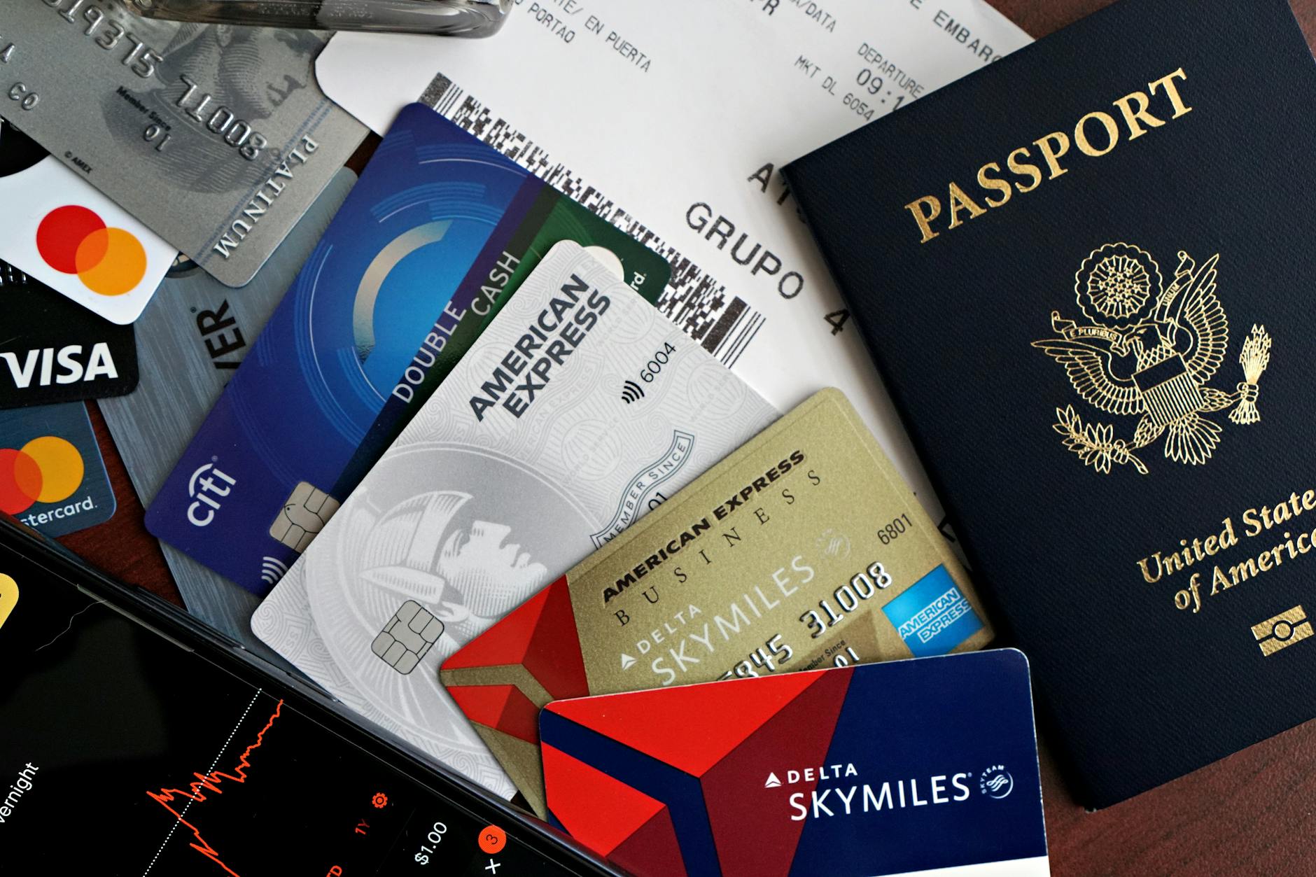 Pasaporte, tarjeta de crédito y documentos sobre una mesa antes de un viaje