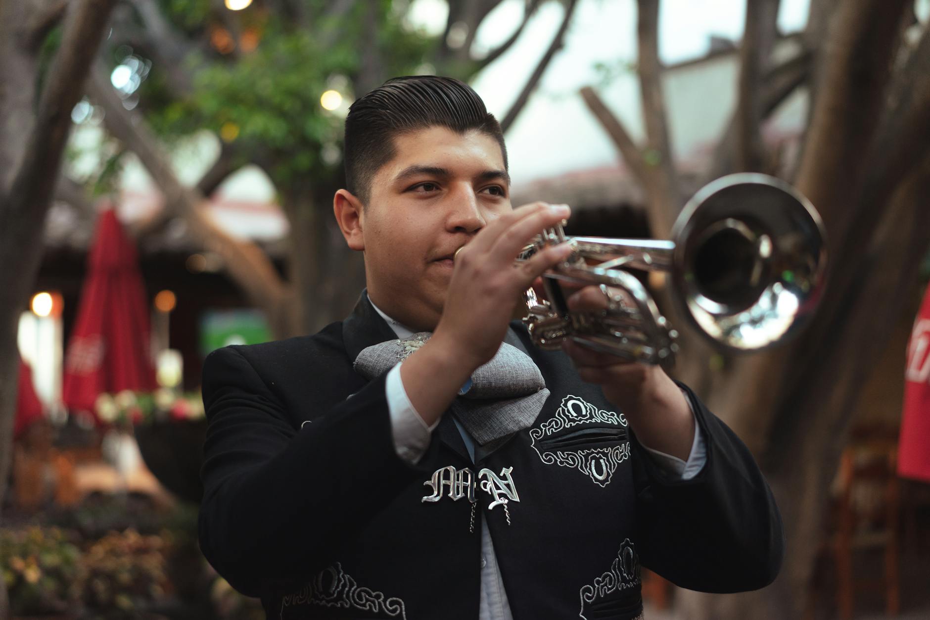 Músicos de mariachi con traje de charro tocando en una plaza de Guadalajara, México
