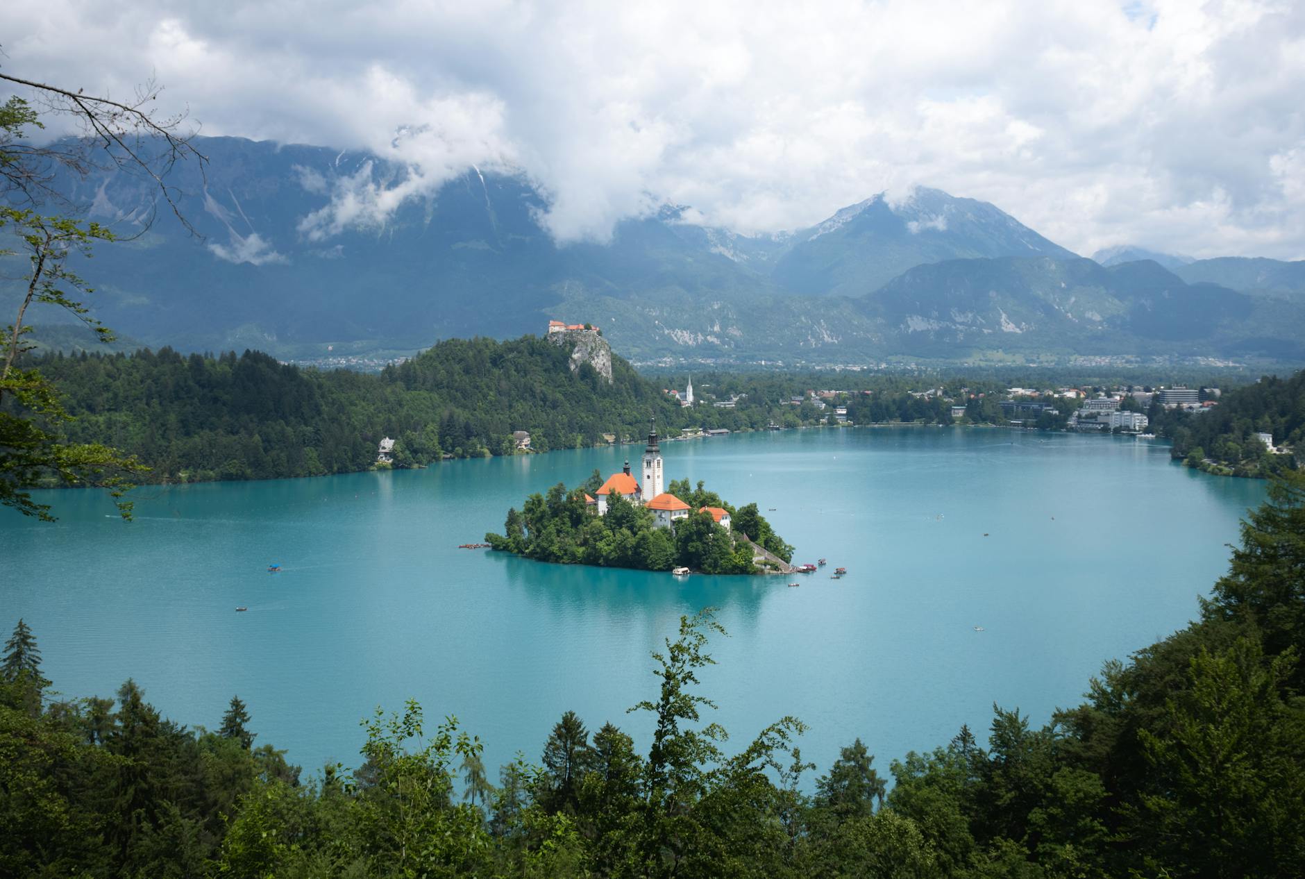 Isla con iglesia blanca en el centro del Lago Bled rodeada de montañas y bosques