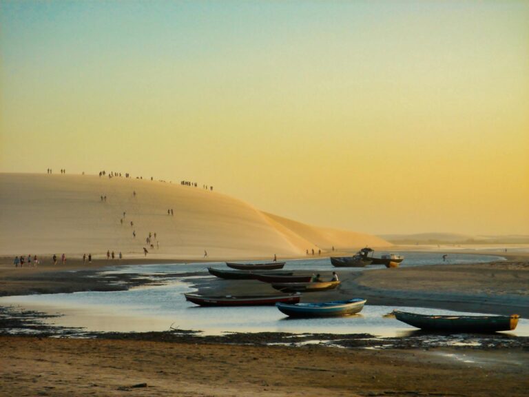 Dunas de arena rojiza en Jericoacoara con el sol poniéndose en el horizonte