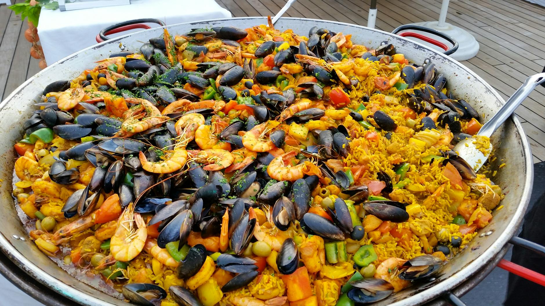Paella valenciana tradicional cocinada en paellera sobre fuego de leña