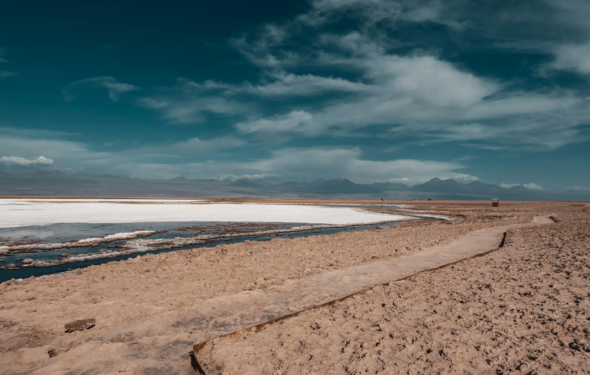 Paisaje rojizo del desierto de Atacama con volcanes al fondo al atardecer