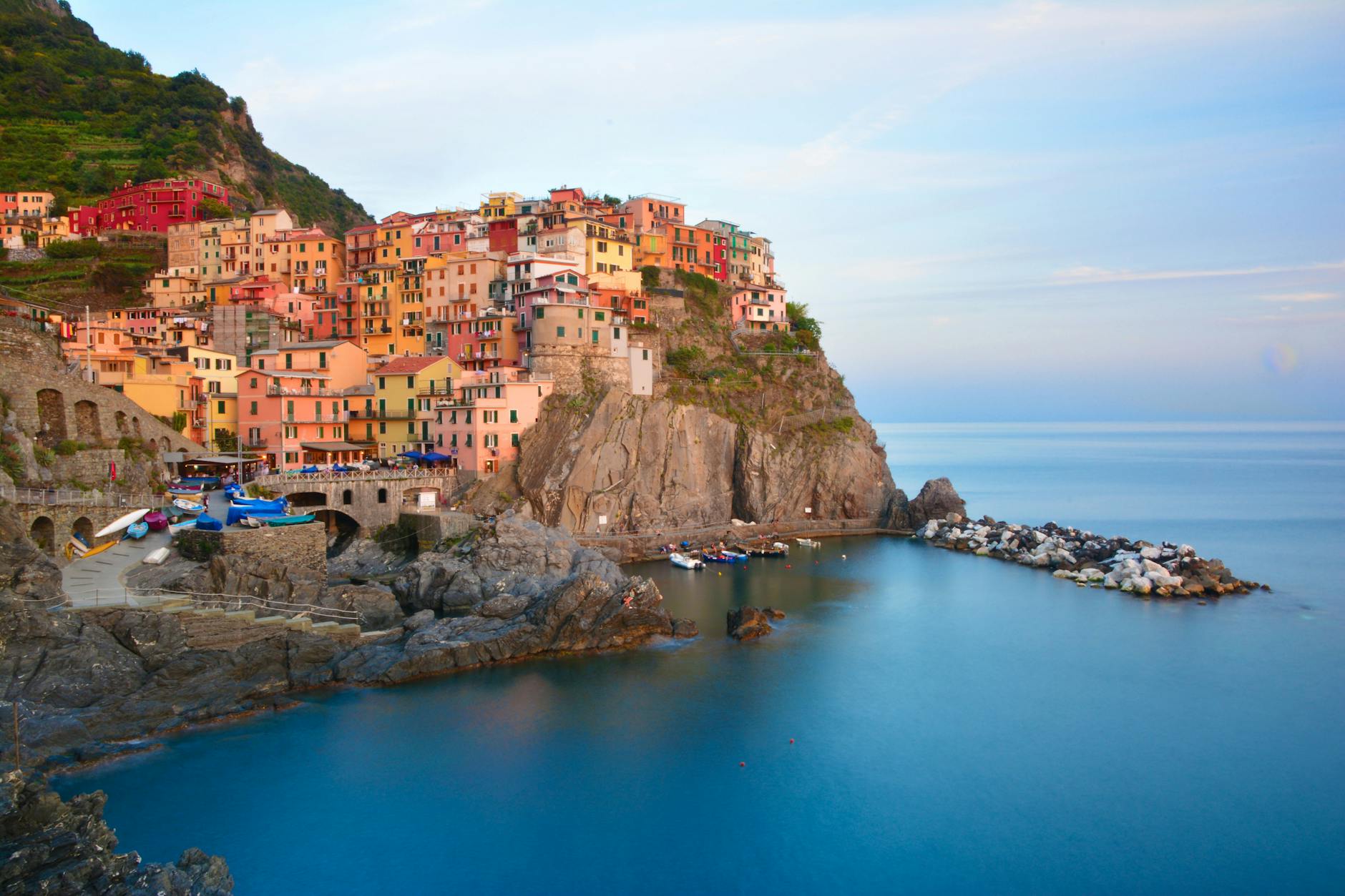 Atardecer sobre Manarola con el mar de Liguria al fondo y las casas de colores reflejadas en el agua