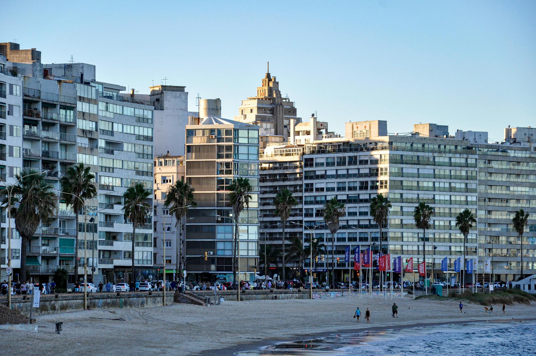 Personas paseando por la Rambla de Montevideo con el Río de la Plata al fondo