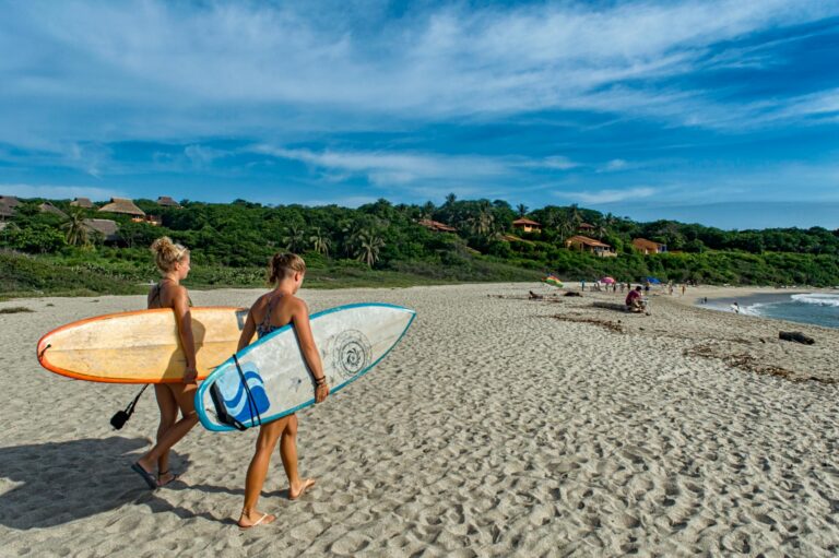 Playa Zicatela con olas grandes y cielo naranja al atardecer en Puerto Escondido