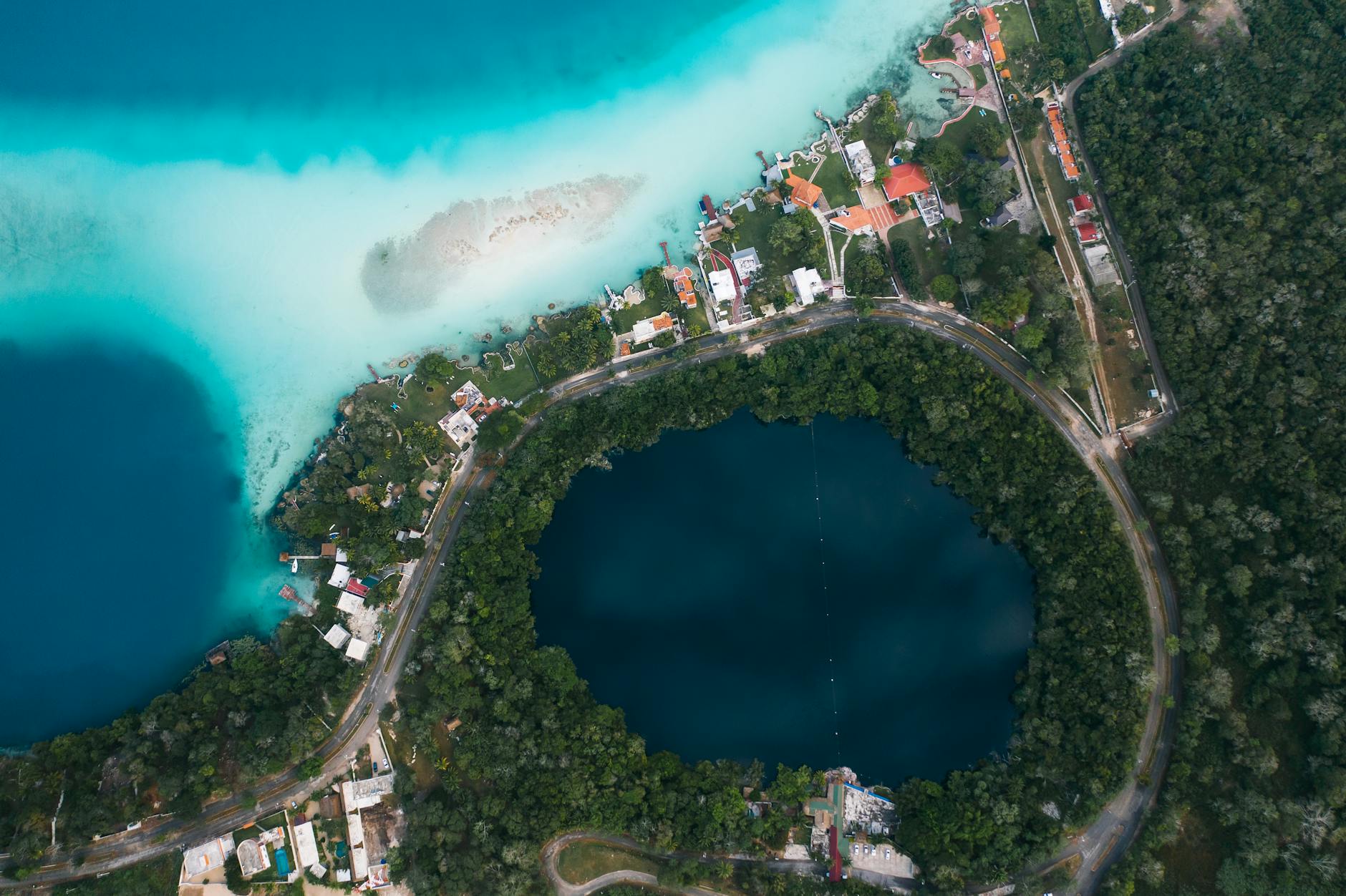 Aguas turquesas de la laguna de Bacalar con un muelle de madera en primer plano