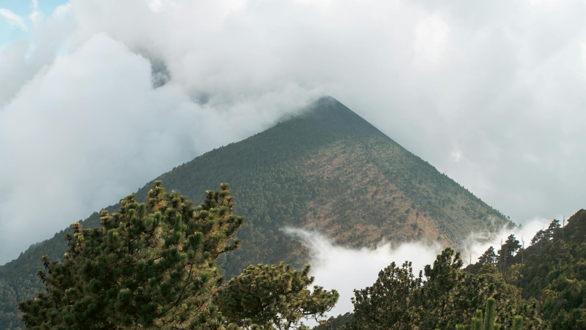 Amanecer sobre las nubes desde la cumbre del Acatenango con el volcán de Fuego al fondo