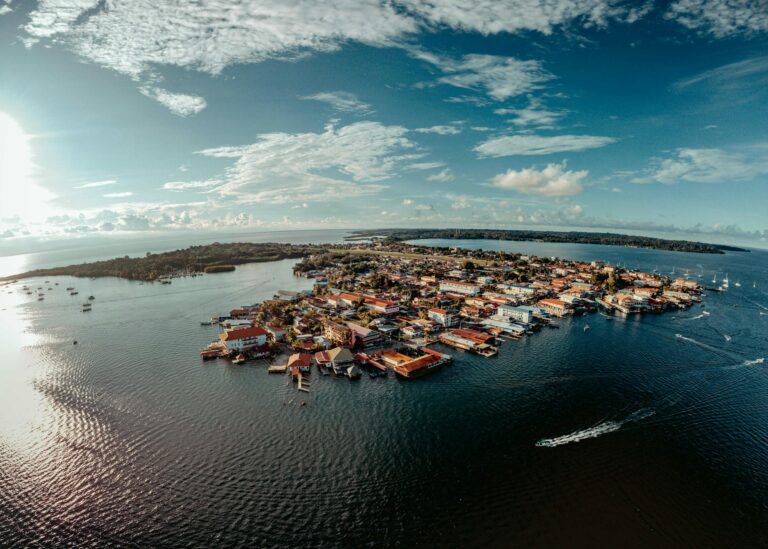 Vista panorámica de la isla de Flores y el lago Petén Itzá con el cielo anaranjado al atardecer