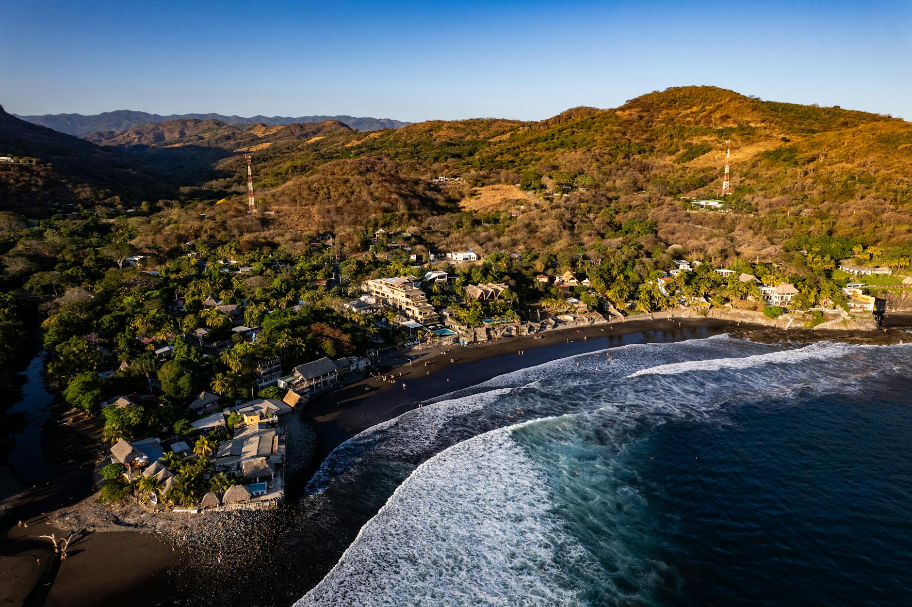 Atardecer anaranjado sobre las rocas volcánicas de El Tunco en El Salvador